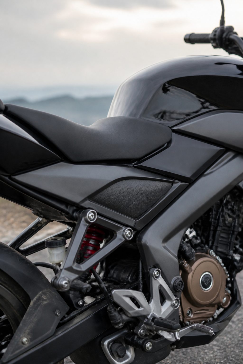 Naked bir motosikletin sağ yan profilinde, yakıt deposunun altından geçen perimetre şasi kolları ile arka monoşok amortisörün üst bağlantı noktası